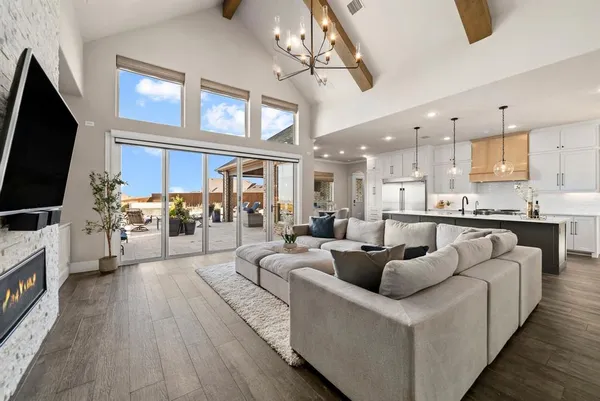 a living room with furniture a flat screen tv and kitchen view