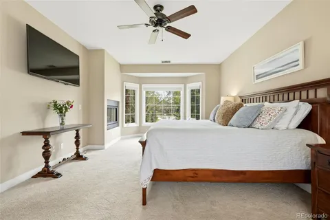 a bedroom with a bed a flat screen tv and a window
