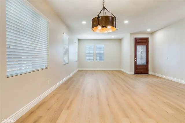 a kitchen with stainless steel appliances kitchen island granite countertop a stove top oven a sink dishwasher a refrigerator and a oven with wooden floor