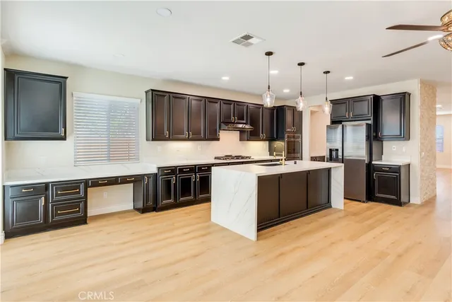 a kitchen with kitchen island a stove a sink a kitchen island with wooden cabinets and floor