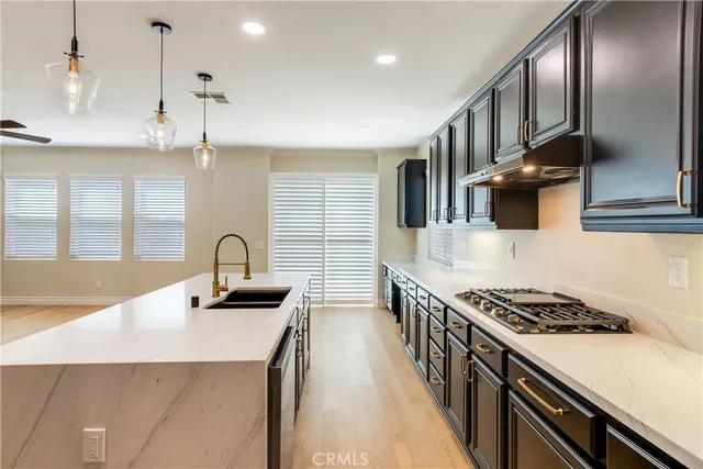 a view of an empty room with a kitchen and a window