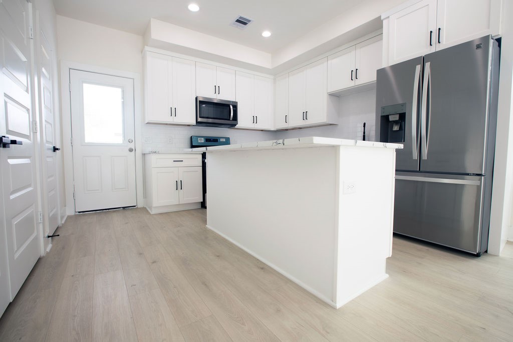 4137 Mallow Street, Unit A Houston, TX 77051 - Photo 14 of 16 a kitchen with stainless steel appliances a refrigerator sink and white cabinets