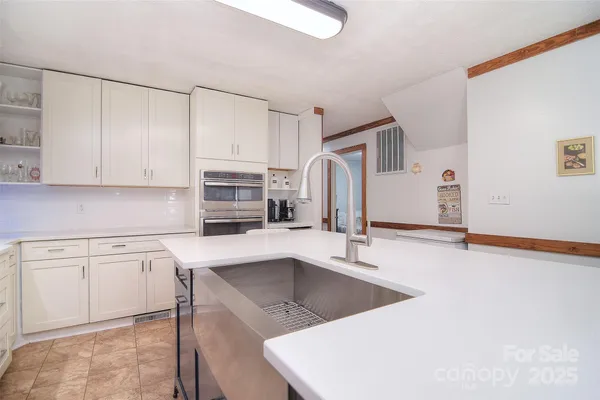a kitchen with white cabinets and stove
