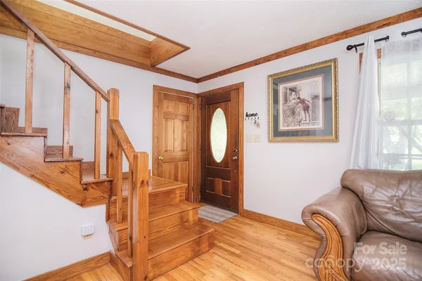 a living room with furniture and a large window with wooden floor