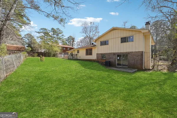 a view of a house with a backyard and a tree