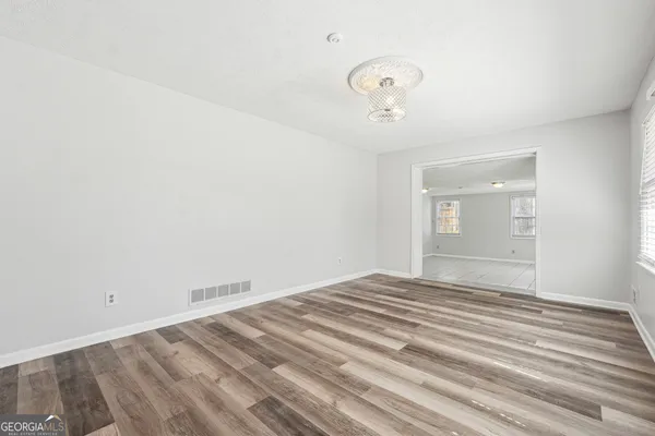 a view of empty room with wooden floor