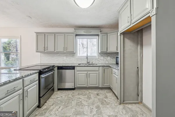 a kitchen with stainless steel appliances granite countertop a sink stove and refrigerator