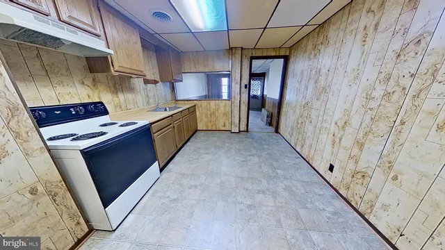 a kitchen with stainless steel appliances granite countertop a refrigerator a stove and a sink