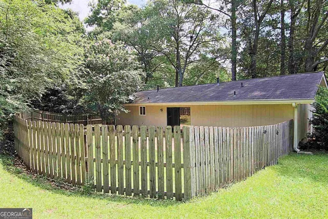 a view of a house with a wooden fence