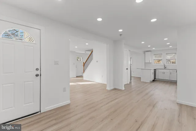 a view of a big room with wooden floor and windows