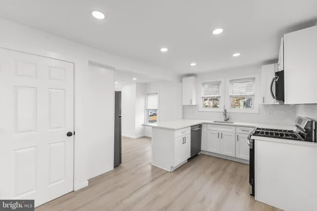 a kitchen with white cabinets and stainless steel appliances