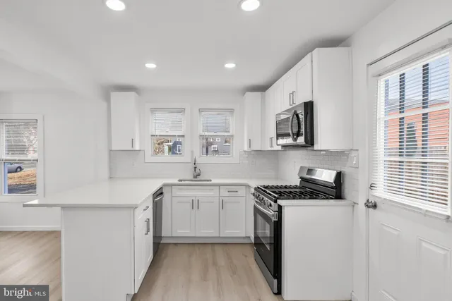 a kitchen with cabinets a sink a window and stainless steel appliances