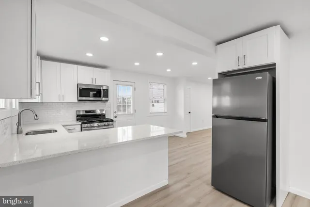 a kitchen with stainless steel appliances granite countertop a refrigerator a stove a sink and a microwave