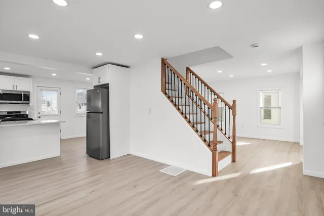 a view of kitchen with stainless steel appliances a refrigerator and wooden floor