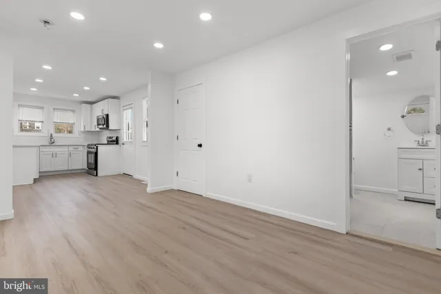 a view of a kitchen with a sink and dishwasher a refrigerator with wooden floor