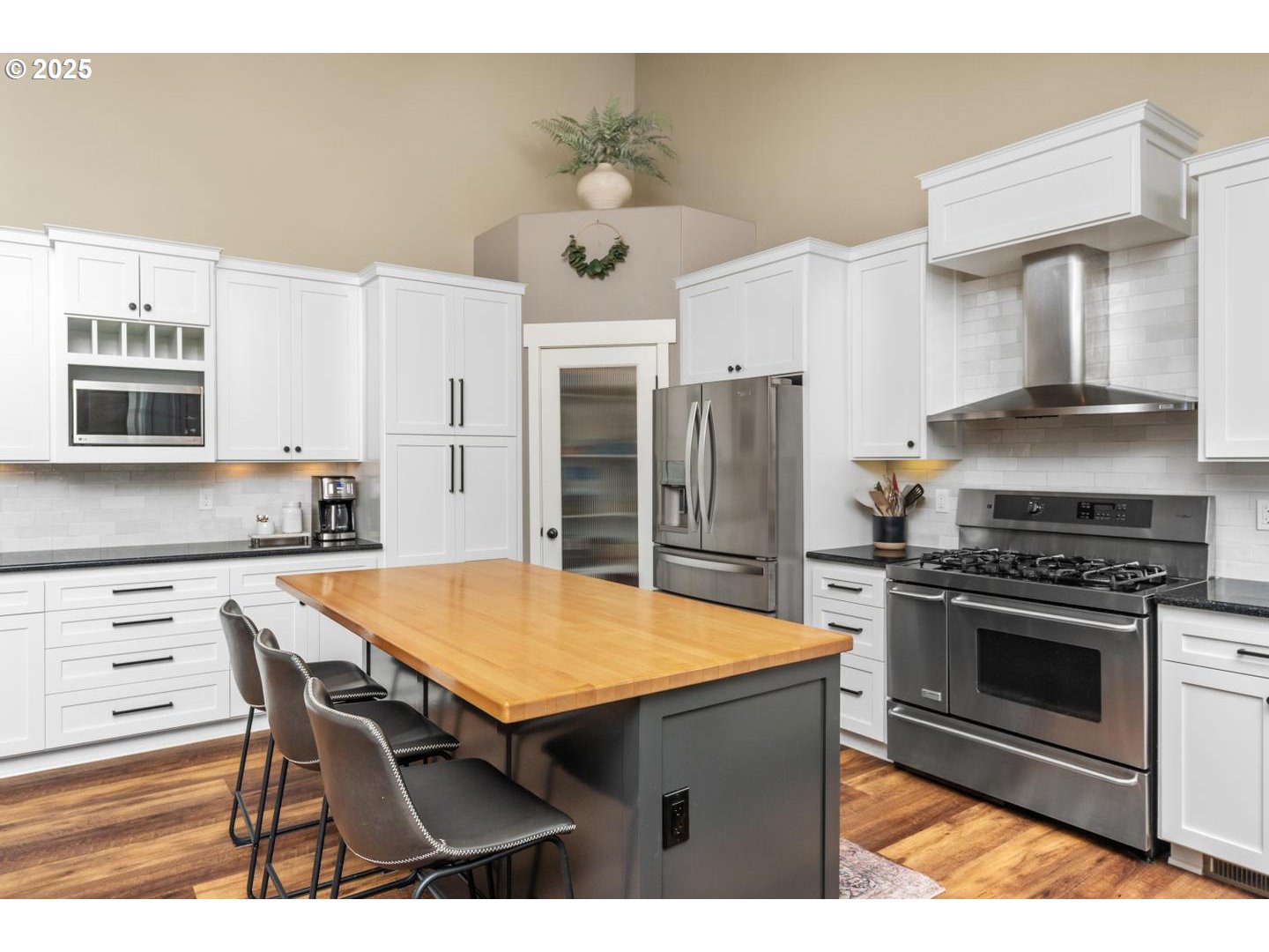 21481 South Ridge Road Oregon City, OR 97045 - Photo 14 of 48 a kitchen with stainless steel appliances a stove a refrigerator a kitchen island with white cabinets and wooden floor