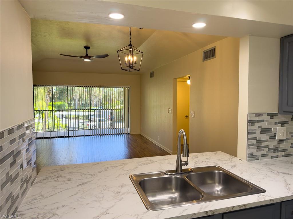 1801 Courtyard Way, Unit D201 Naples, FL 34112 - Photo 11 of 37 a kitchen with a sink a counter top space and cabinets