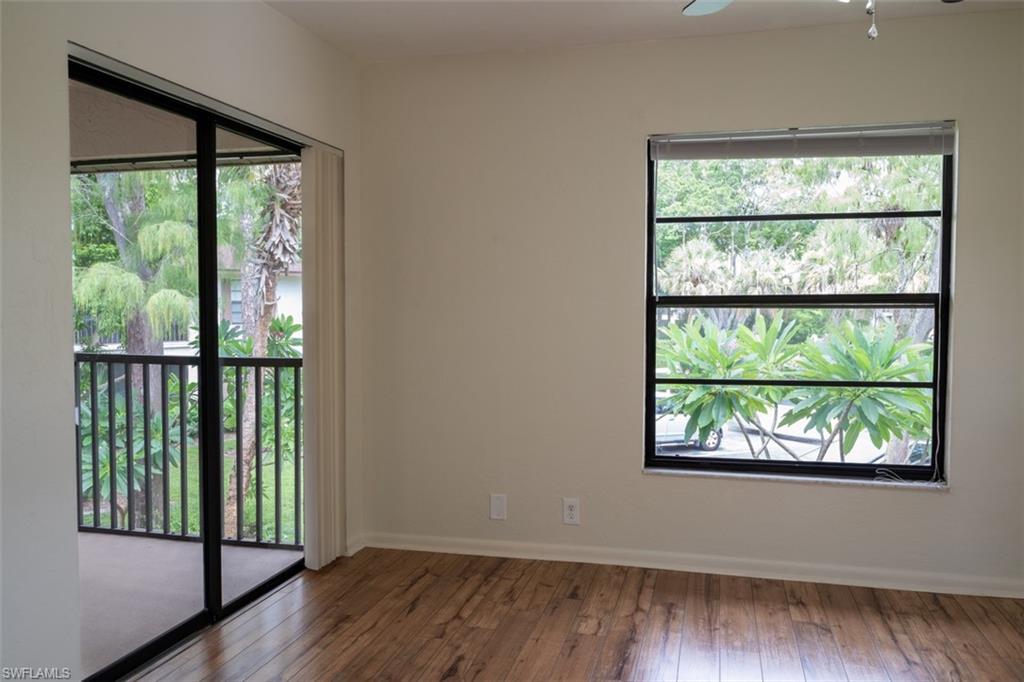1801 Courtyard Way, Unit D201 Naples, FL 34112 - Photo 15 of 37 an empty room with wooden floor and windows