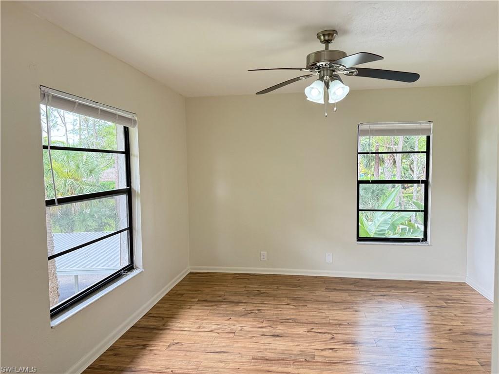 1801 Courtyard Way, Unit D201 Naples, FL 34112 - Photo 16 of 37 a view of an empty room with wooden floor and a window