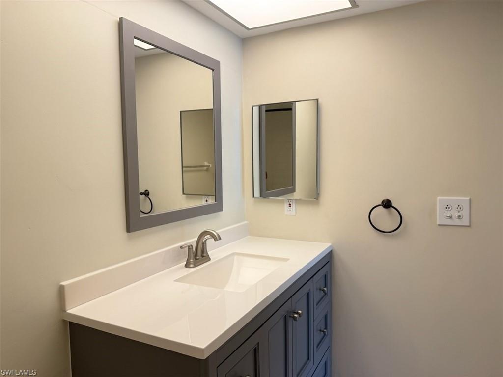 1801 Courtyard Way, Unit D201 Naples, FL 34112 - Photo 20 of 37 a bathroom with a sink and a mirror