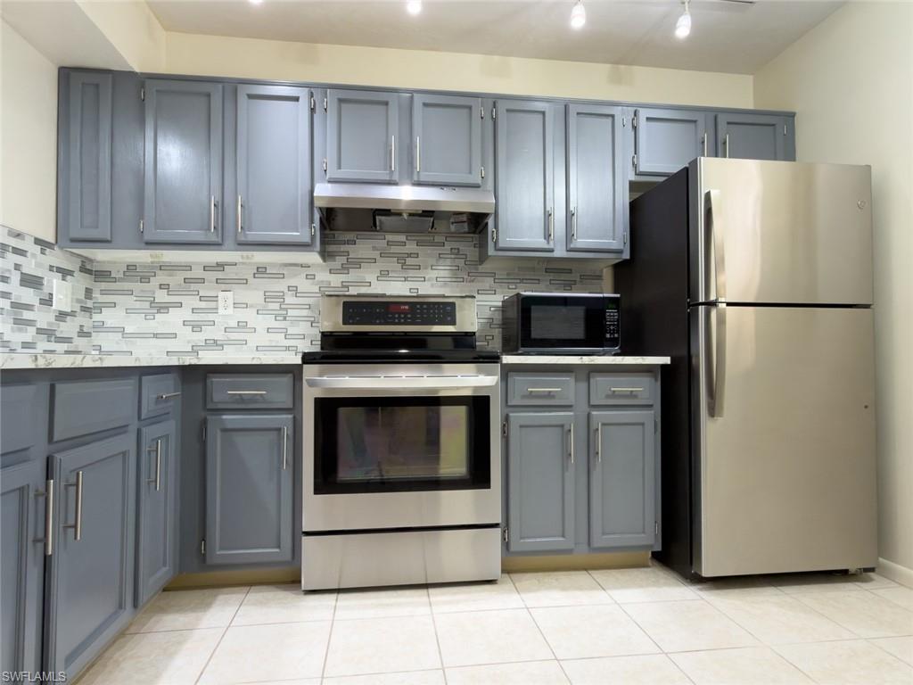 1801 Courtyard Way, Unit D201 Naples, FL 34112 - Photo 2 of 37 a kitchen with appliances a refrigerator and cabinets
