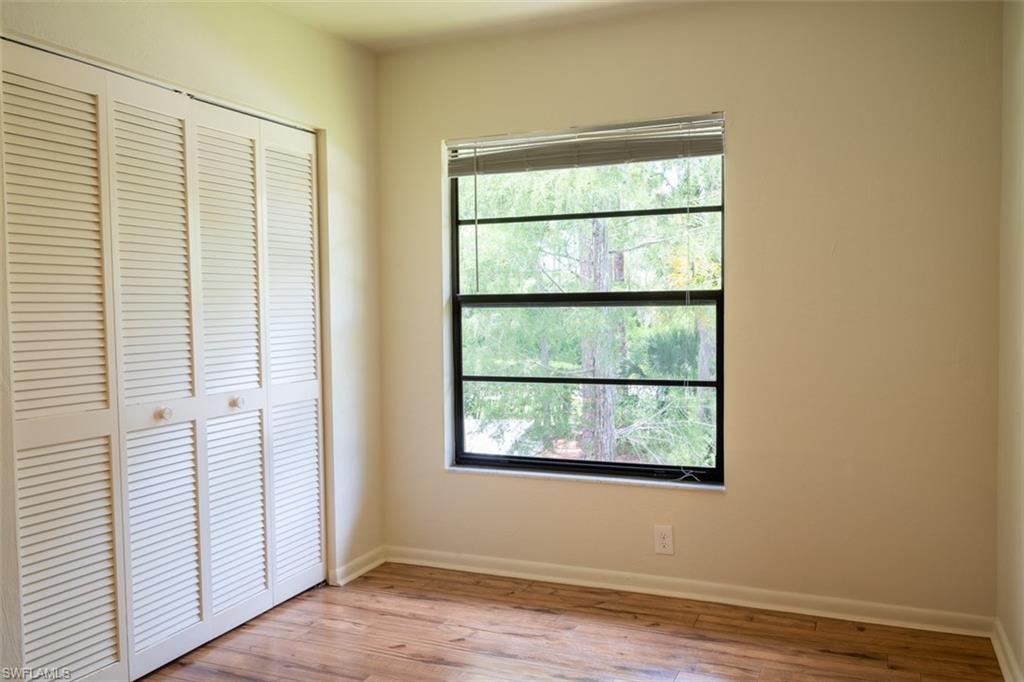 1801 Courtyard Way, Unit D201 Naples, FL 34112 - Photo 22 of 37 an empty room with wooden floor and windows