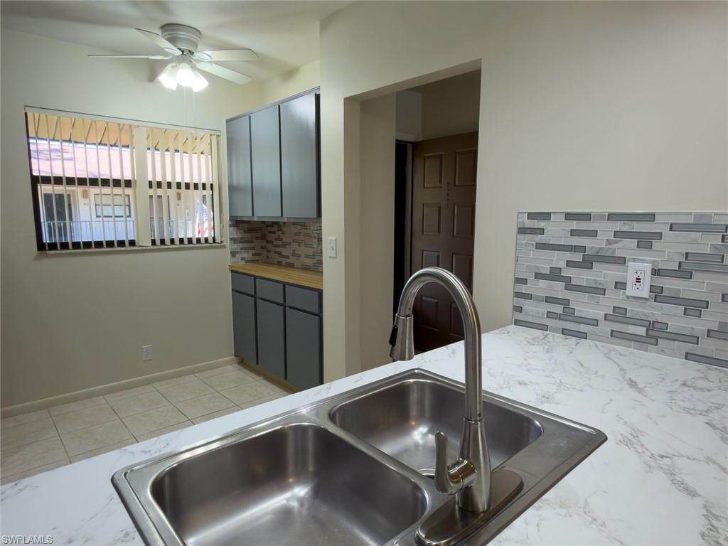 1801 Courtyard Way, Unit D201 Naples, FL 34112 - Photo 3 of 37 a kitchen with a sink and a refrigerator