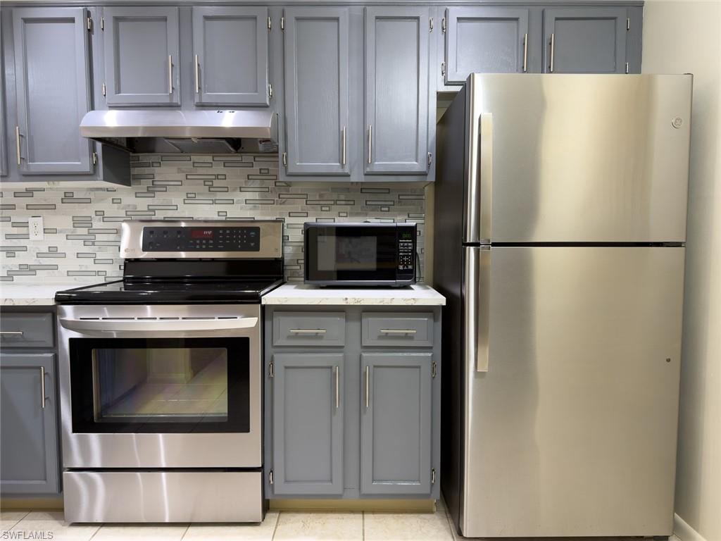 1801 Courtyard Way, Unit D201 Naples, FL 34112 - Photo 6 of 37 a white refrigerator freezer and a stove sitting inside of a kitchen