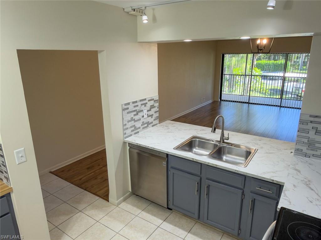 1801 Courtyard Way, Unit D201 Naples, FL 34112 - Photo 8 of 37 a kitchen with a sink and large window