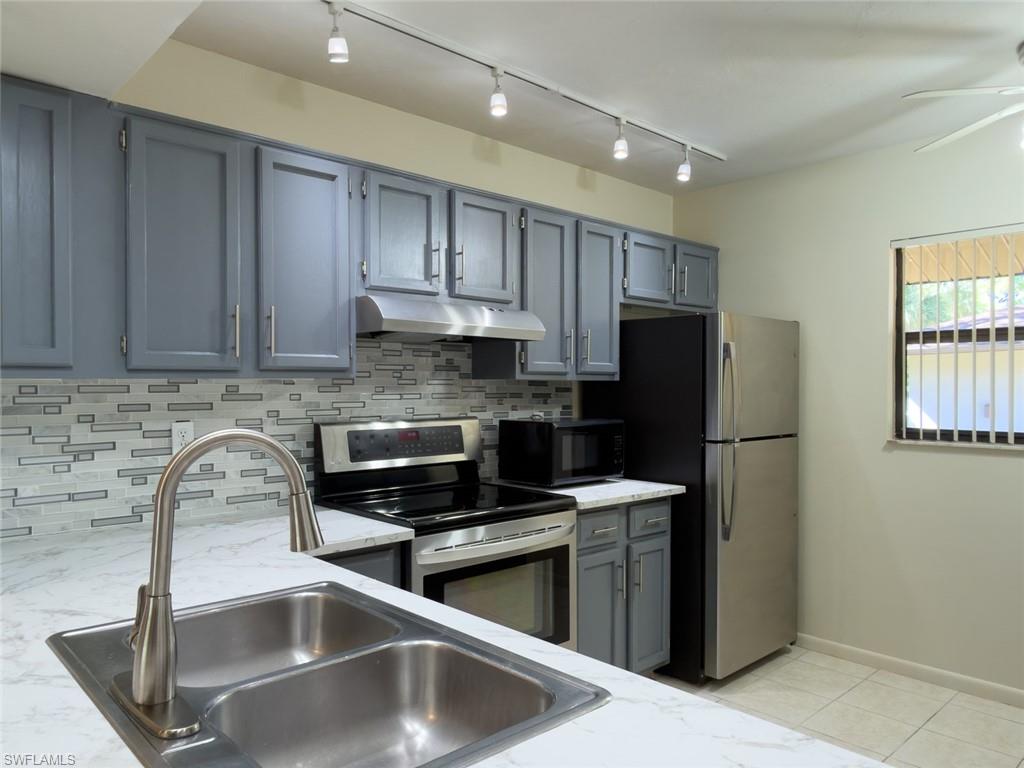1801 Courtyard Way, Unit D201 Naples, FL 34112 - Photo 9 of 37 a kitchen with stainless steel appliances granite countertop a sink a stove a refrigerator a window and a counter space