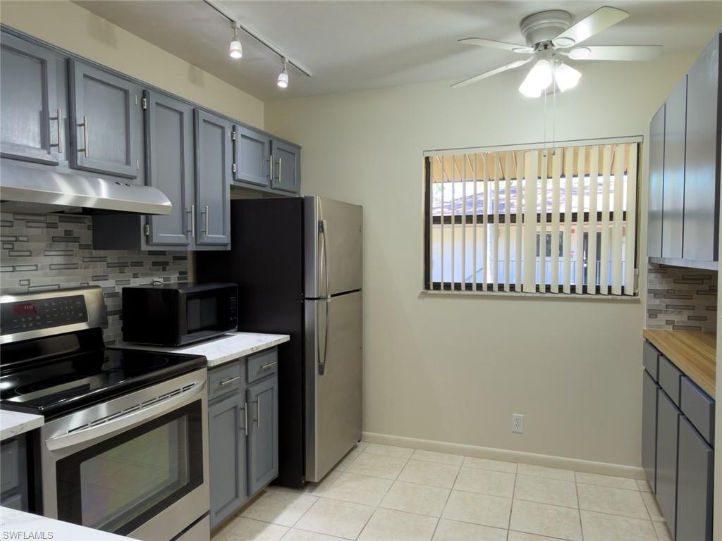 1801 Courtyard Way, Unit D201 Naples, FL 34112 - Photo 10 of 37 a kitchen with a stove a refrigerator and a sink
