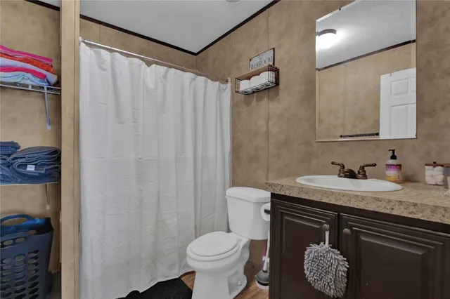 a bathroom with a granite countertop sink and a toilet