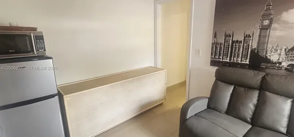 a view of living room with furniture and a refrigerator