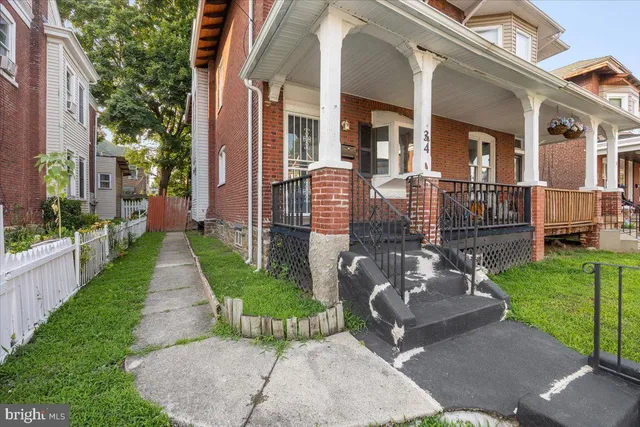 a view of a brick house with a yard garden and plants