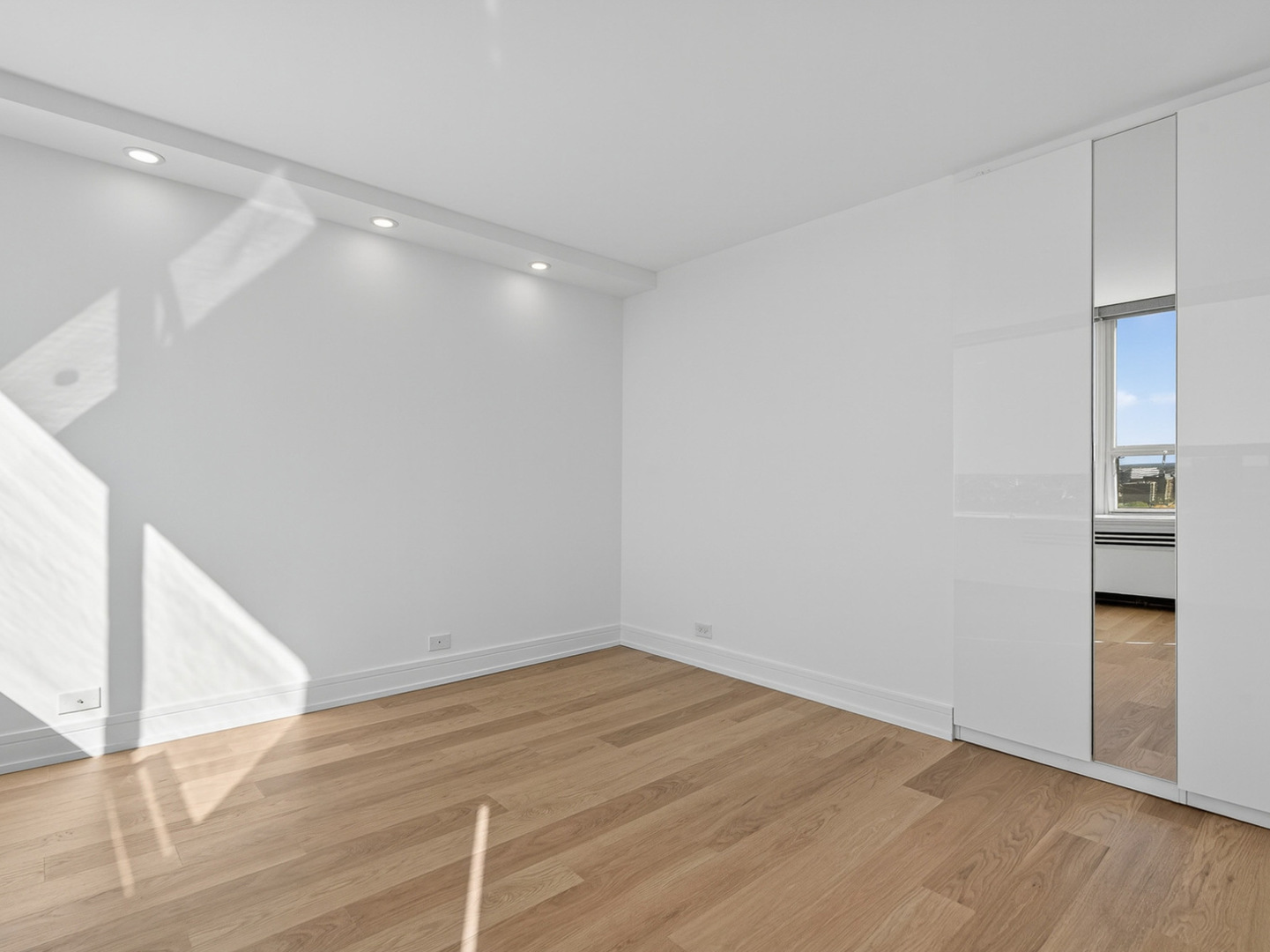 1455 North Sandburg Terrace, Unit 2403 Chicago, IL 60610 - Photo 11 of 22 a view of an empty room with wooden floor and a bathroom