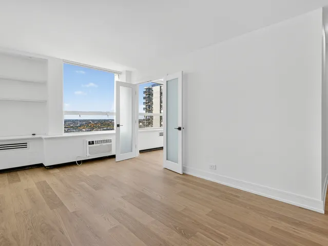 a view of a room with an empty room and wooden floor