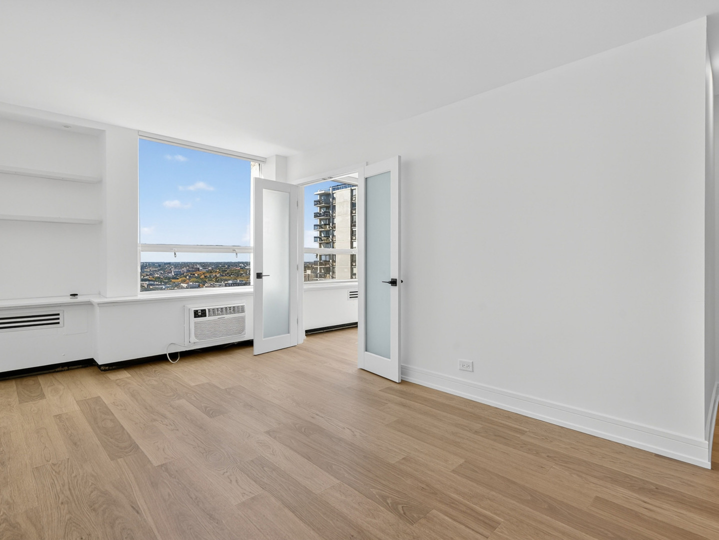1455 North Sandburg Terrace, Unit 2403 Chicago, IL 60610 - Photo 3 of 22 a view of a room with an empty room and wooden floor