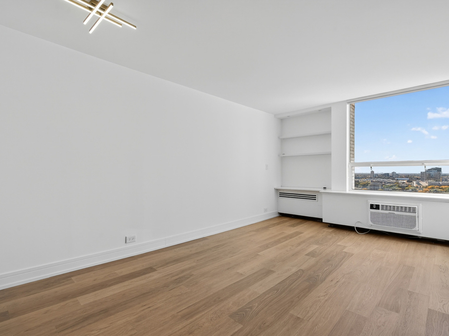 1455 North Sandburg Terrace, Unit 2403 Chicago, IL 60610 - Photo 6 of 22 wooden floor in an empty room with a window