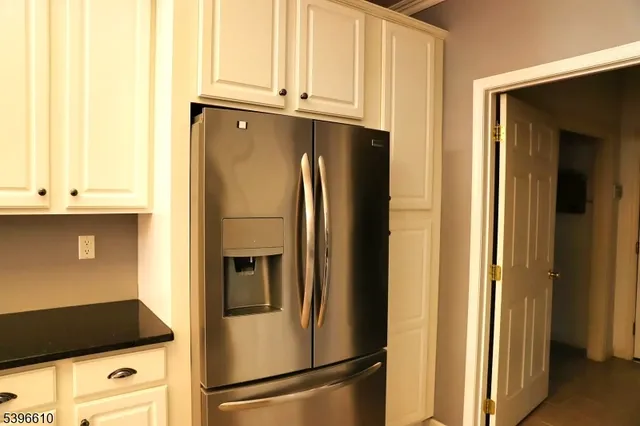 a kitchen with metallic refrigerator and cabinets