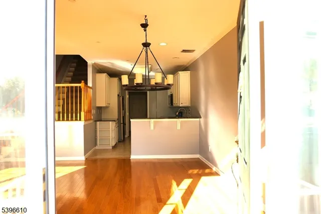 a view of entryway and hall with wooden floor