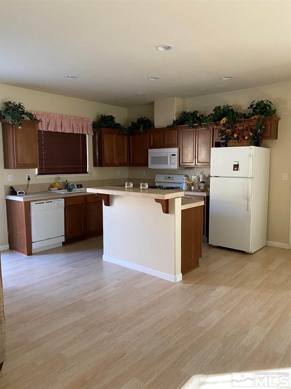 1375 Copper Leaf Drive Reno, NV 89506 - Photo 5 of 20 a kitchen with stainless steel appliances granite countertop a stove top oven a sink and a refrigerator