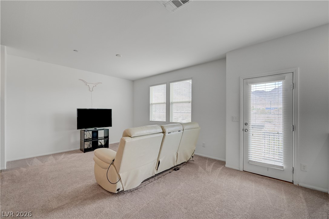 1287 Raritan Place Henderson, NV 89002 - Photo 10 of 21 A comfortable living area with carpeted floors opens to an outdoor space with mountain vistas.