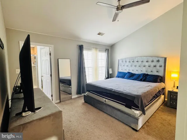 a bedroom with a bed and a flat tv screen on the dresser