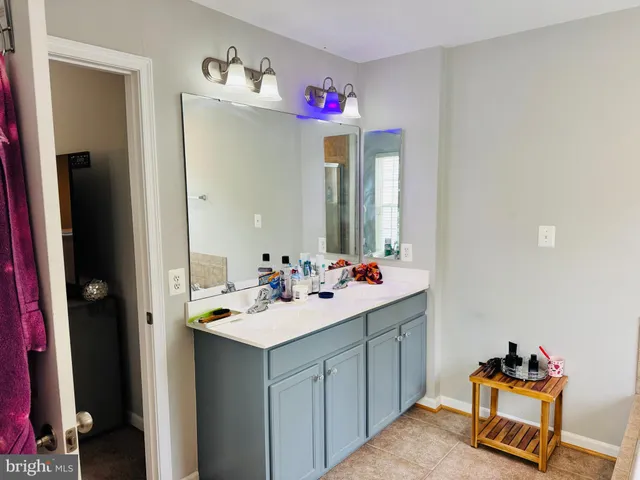 a bathroom with a sink vanity and mirror