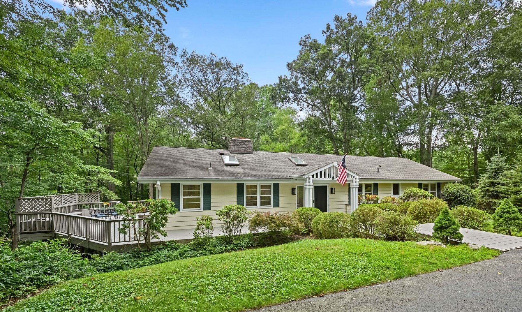 391 Sawmill Road Stamford, CT 06903 - Photo 1 of 1 a front view of a house with a yard table and chairs