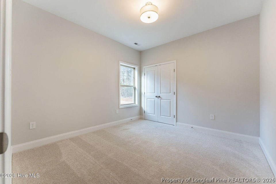 229 Telluride Court Aberdeen, NC 28315 - Photo 14 of 19 an empty room with window and wooden floor