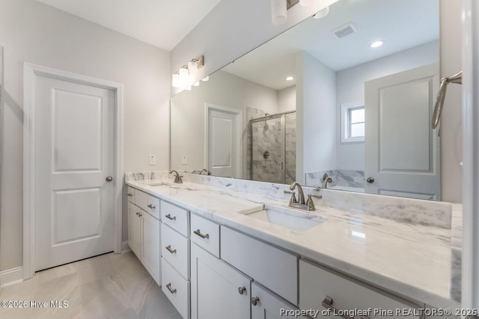 229 Telluride Court Aberdeen, NC 28315 - Photo 9 of 19 a bathroom with double sink and a mirror