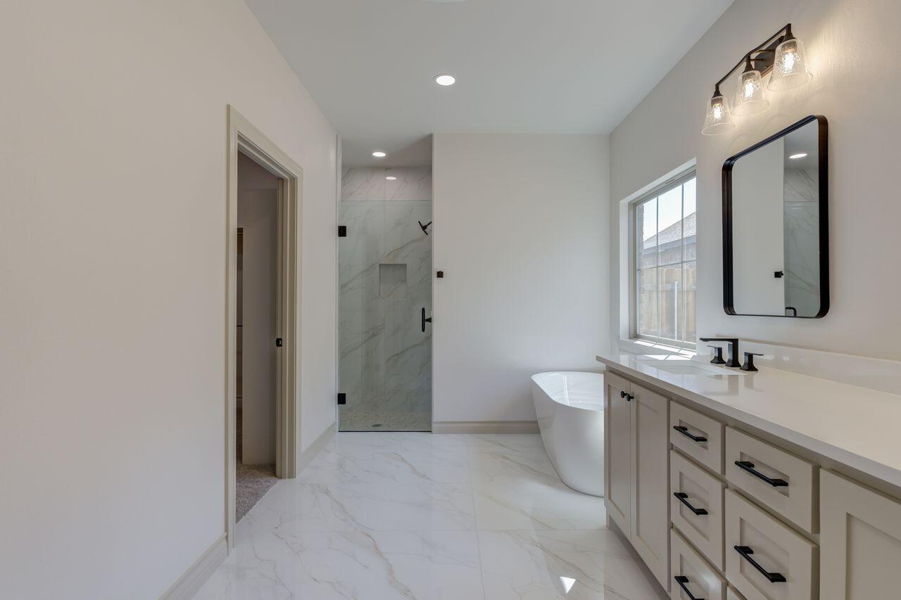5524 120th Street Lubbock, TX 79424 - Photo 33 of 39 a spacious bathroom with a double vanity sink mirror double and shower