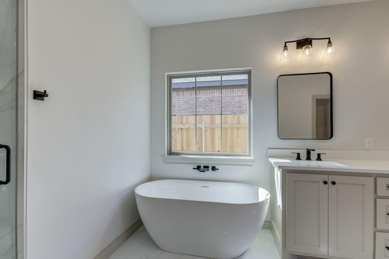 5524 120th Street Lubbock, TX 79424 - Photo 35 of 39 a bathroom with 2 sink and a mirror