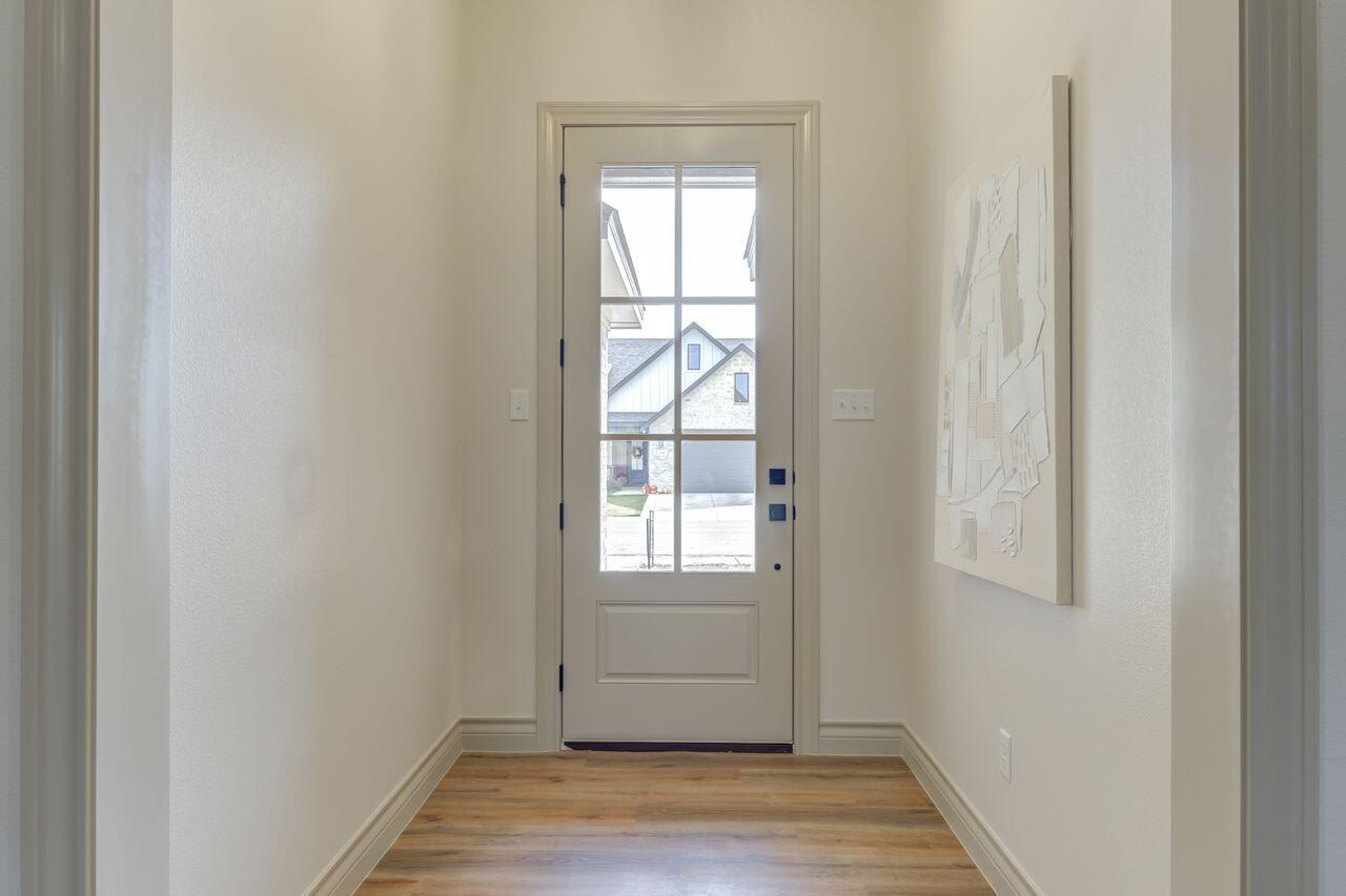 5524 120th Street Lubbock, TX 79424 - Photo 4 of 39 a view of an empty room with wooden floor and a window